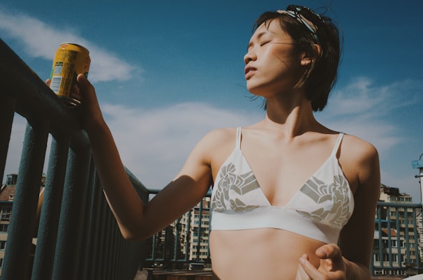 A sunlit morning scene with a woman enjoying a peaceful moment with her wellness supplements on a cozy balcony.