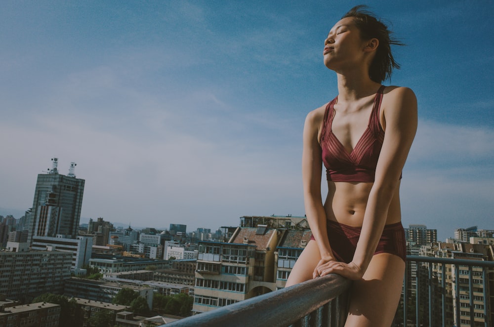 a woman in a bikini standing on a balcony