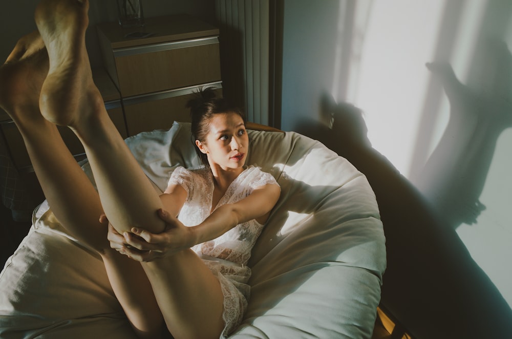 a woman laying in bed with her legs spread out