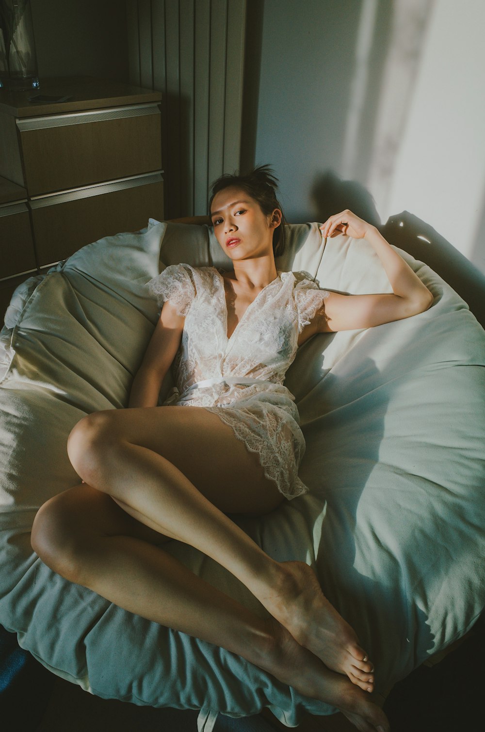 a woman laying on top of a bed next to a pillow