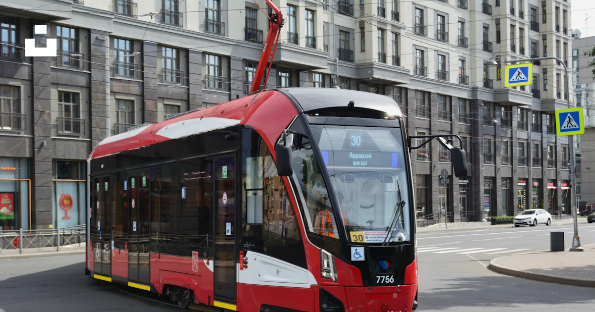 A red and black bus driving down a street photo – Free Russia Image on ...