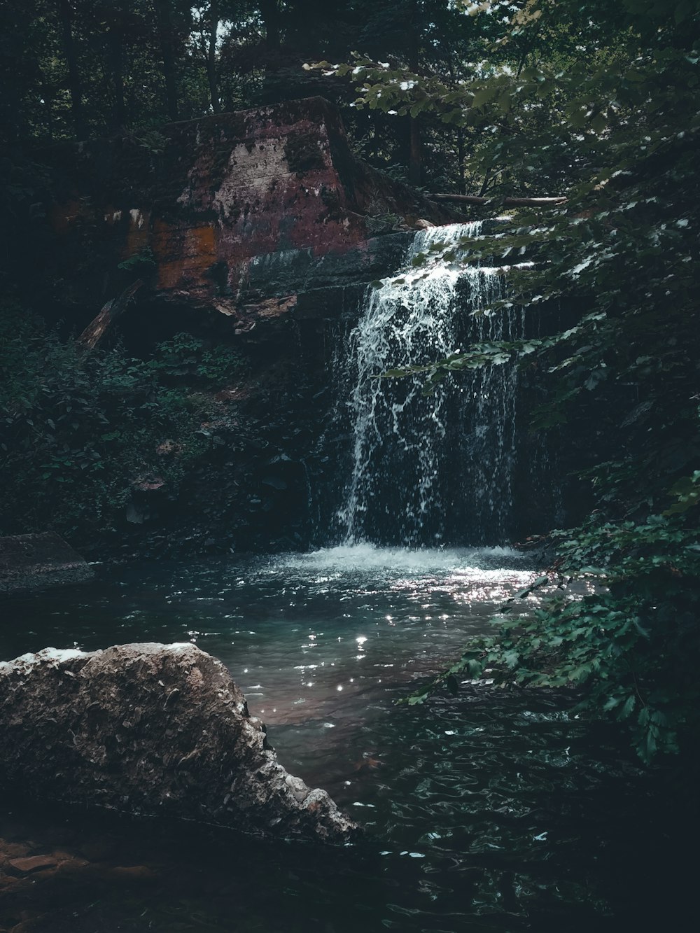 a small waterfall in the middle of a forest