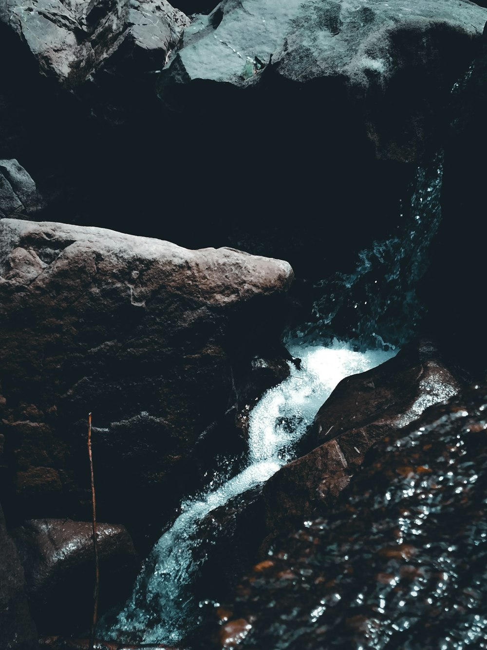 a man standing on top of a rock next to a river