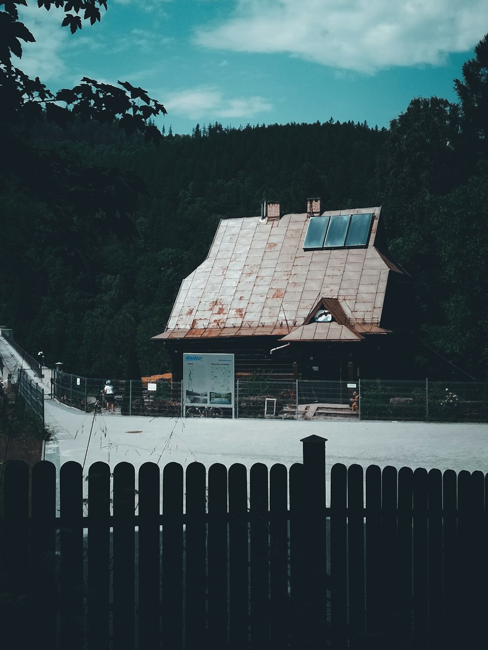 a house with a metal roof and a wooden fence