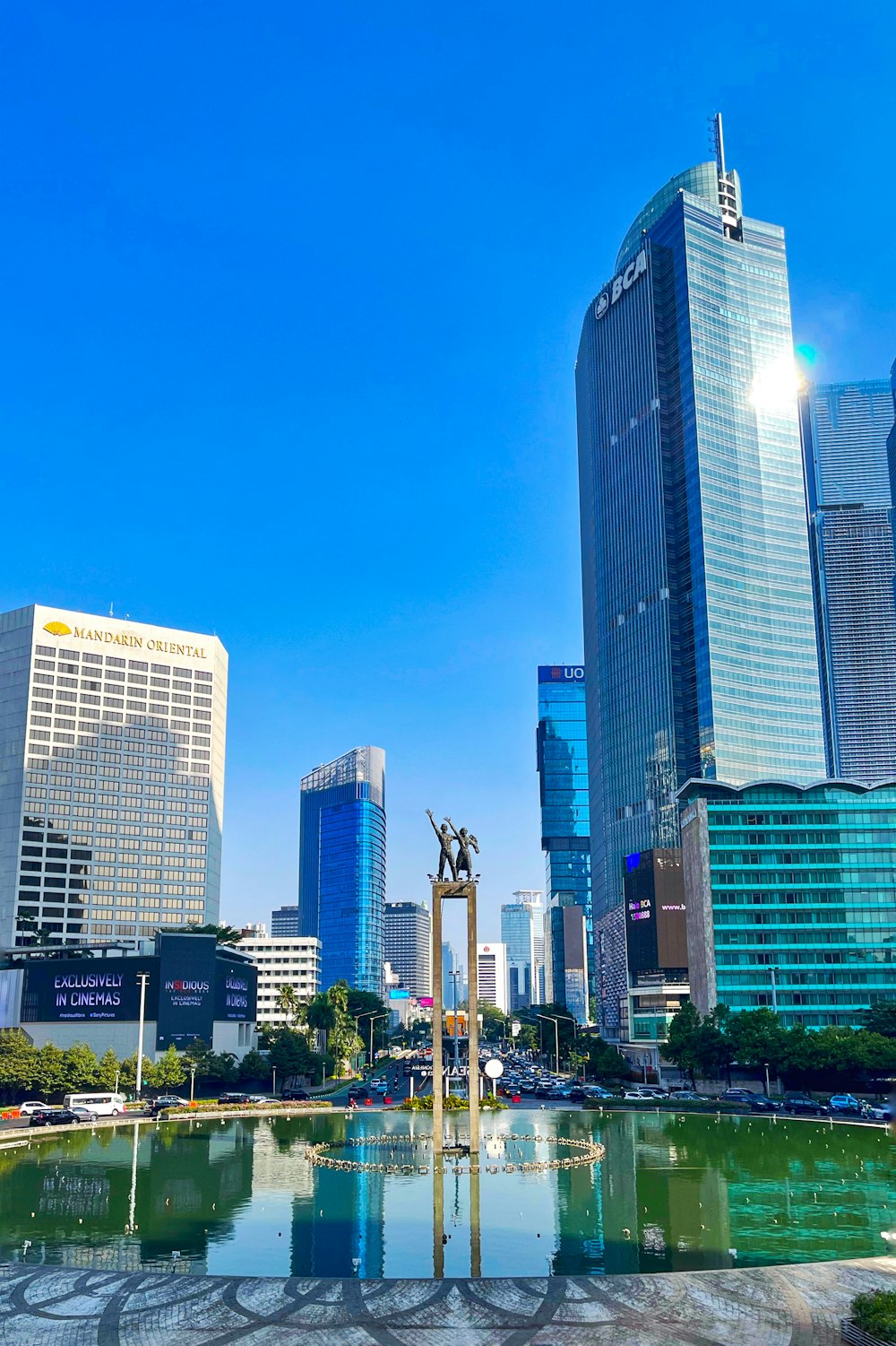 a fountain in a city park with skyscrapers in the background