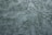 A textured surface with an irregular pattern of raised and recessed areas, resembling stucco or plaster. The surface has a rough, uneven texture with shadows enhancing the depth of the pattern.