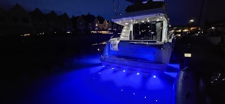 Night view of a yacht illuminated, highlighting its luxury and space for eight people.