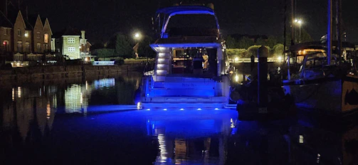A nighttime shot of electric boats glowing softly, docked side by side.