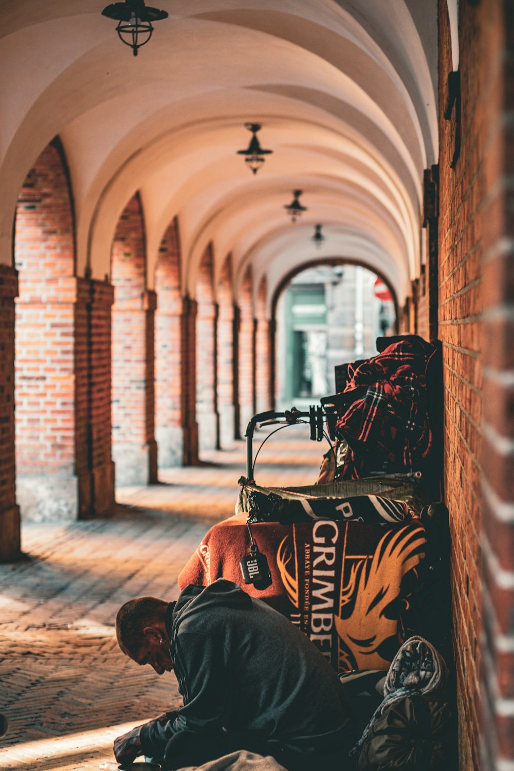 a man sitting on the ground next to a building