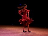 Elegant dancer spinning with a vibrant black and red dress creating a blur of motion.
