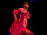 Smiling woman dancing salsa in a vibrant studio with red and black decor.
