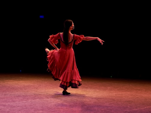 A captivating burlesque dancer performing on stage, illuminated by vibrant lights.