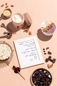 a table topped with bowls of food and a note