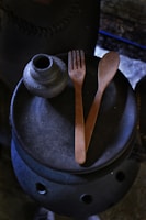 A rustic wooden table displaying an array of textured ceramic pieces under soft natural light.