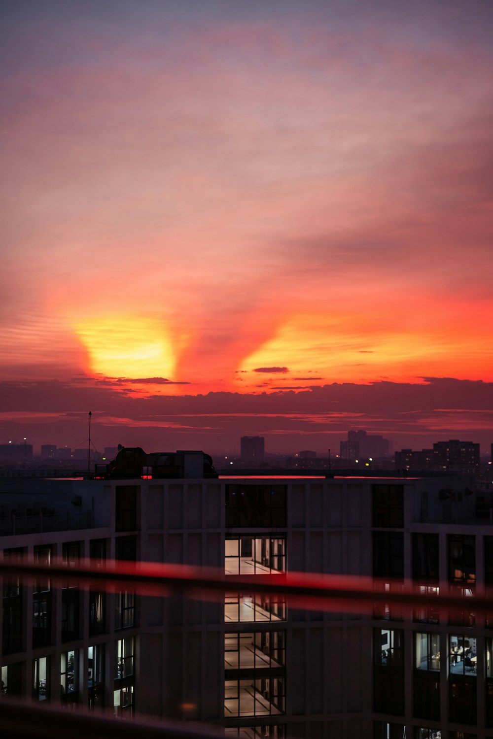 the sun is setting over a city with buildings