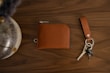 Collection of leather wallets and keychains arranged neatly on a rustic wooden background