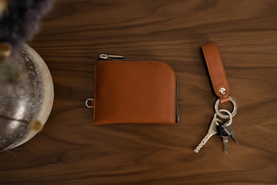 Shiny copper keychain resting on a leather wallet