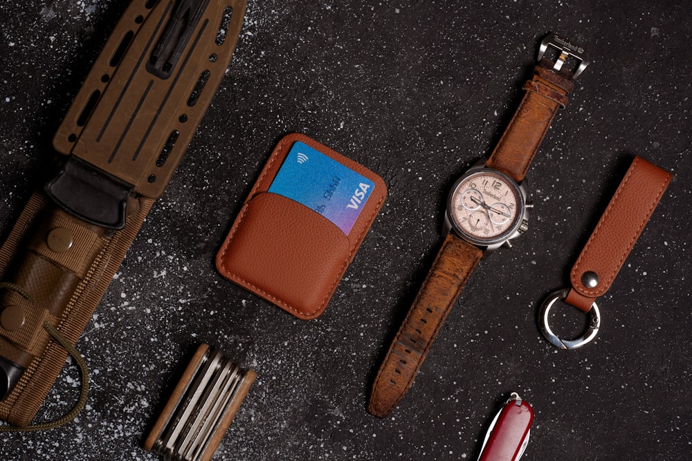 un orologio, un portafoglio e altri oggetti disposti su un tavolo