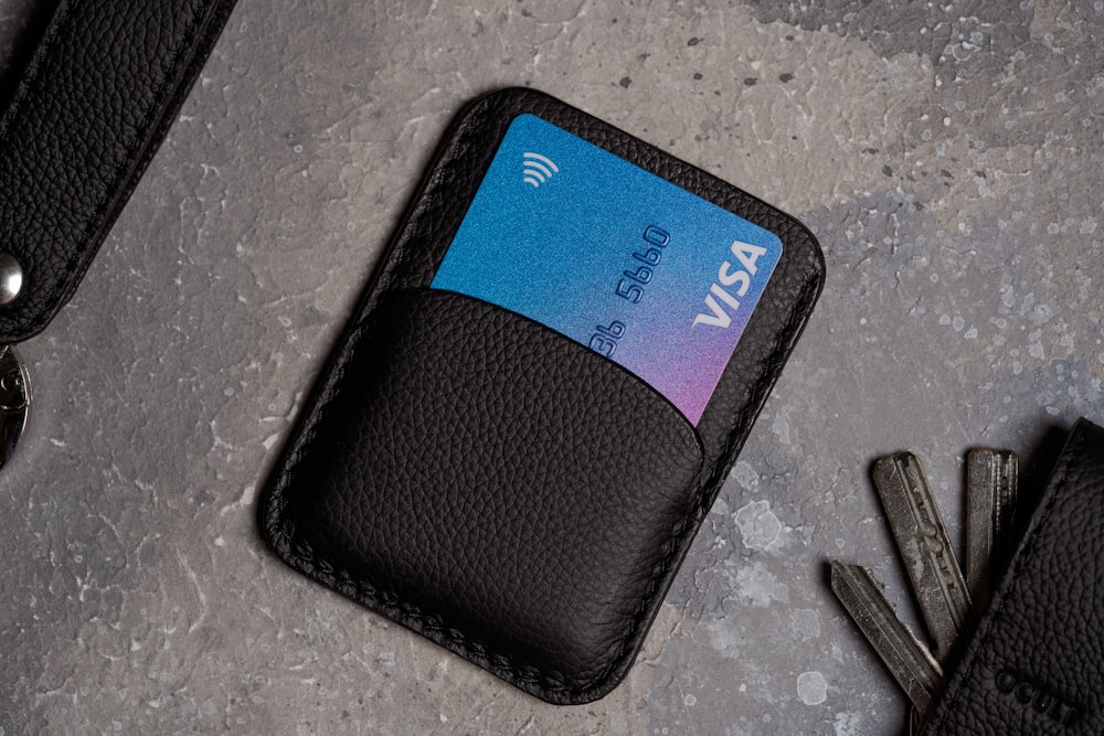 a black wallet with a credit card and keys