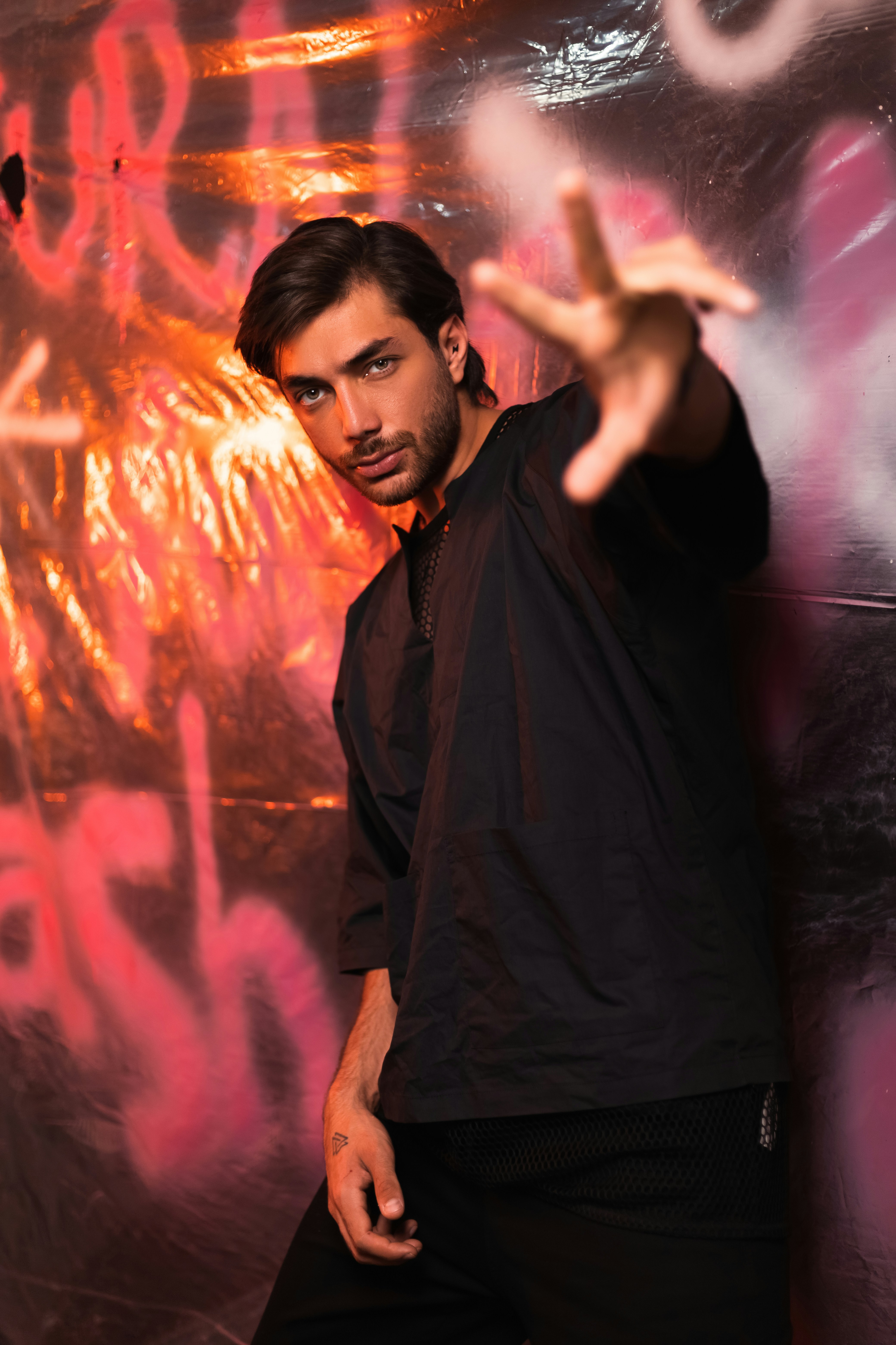a man standing in front of a graffiti covered wall