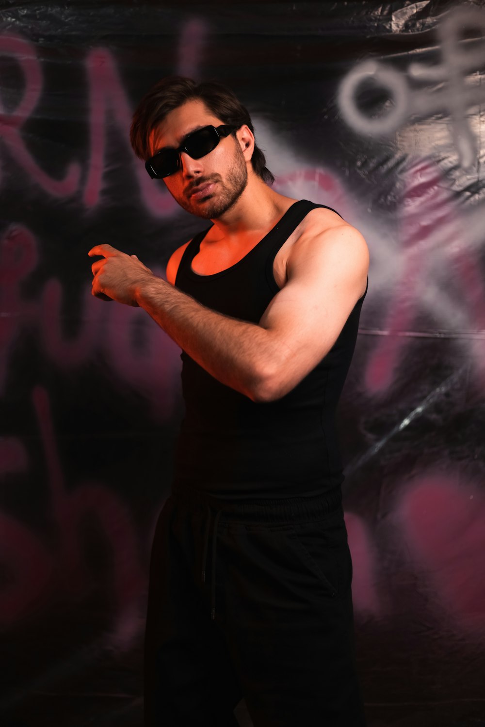 a man in a black tank top and sunglasses
