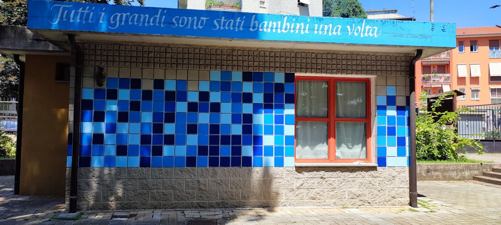 a blue and white building with a red window