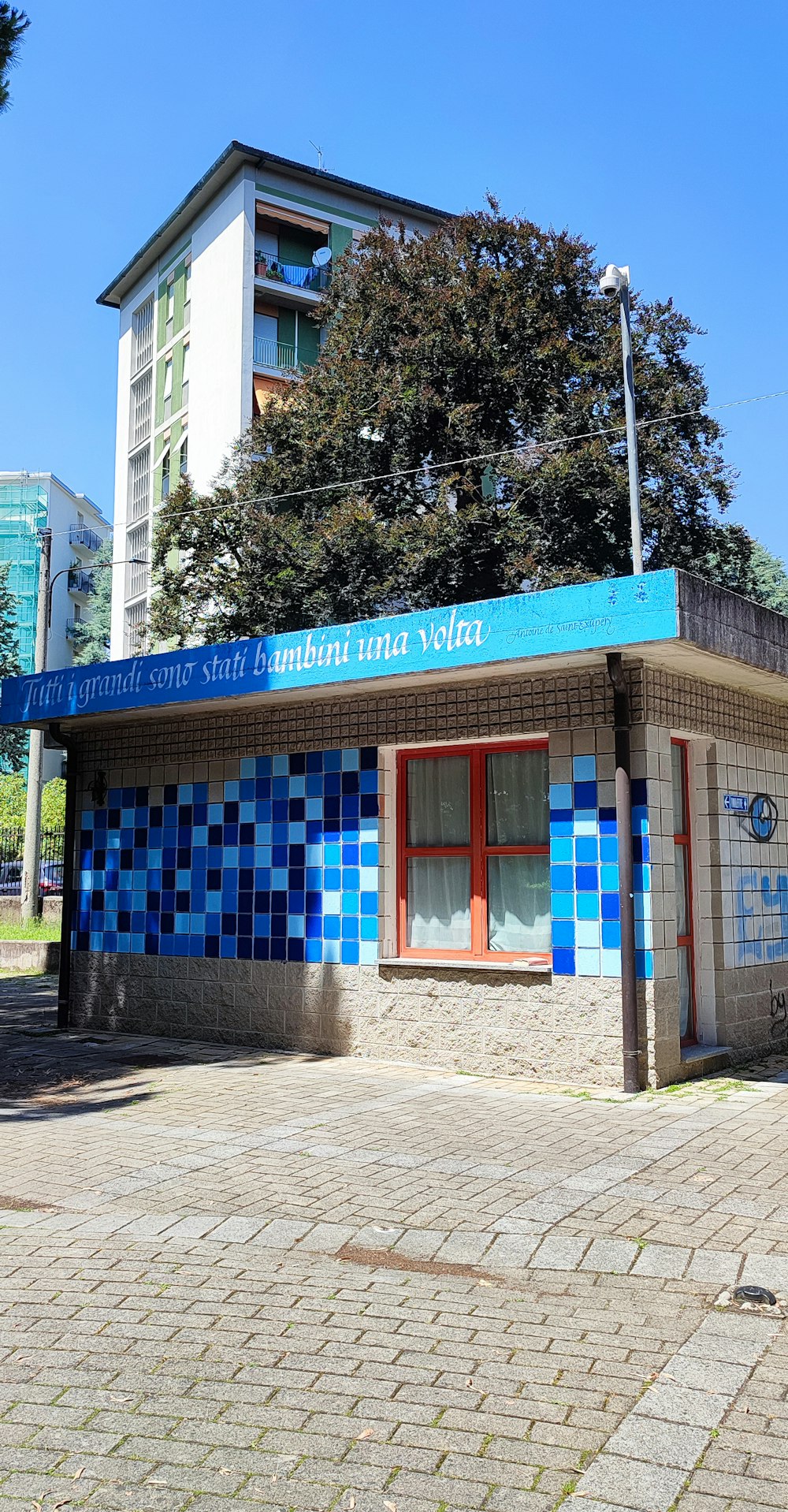 a blue and white building with a tree in front of it