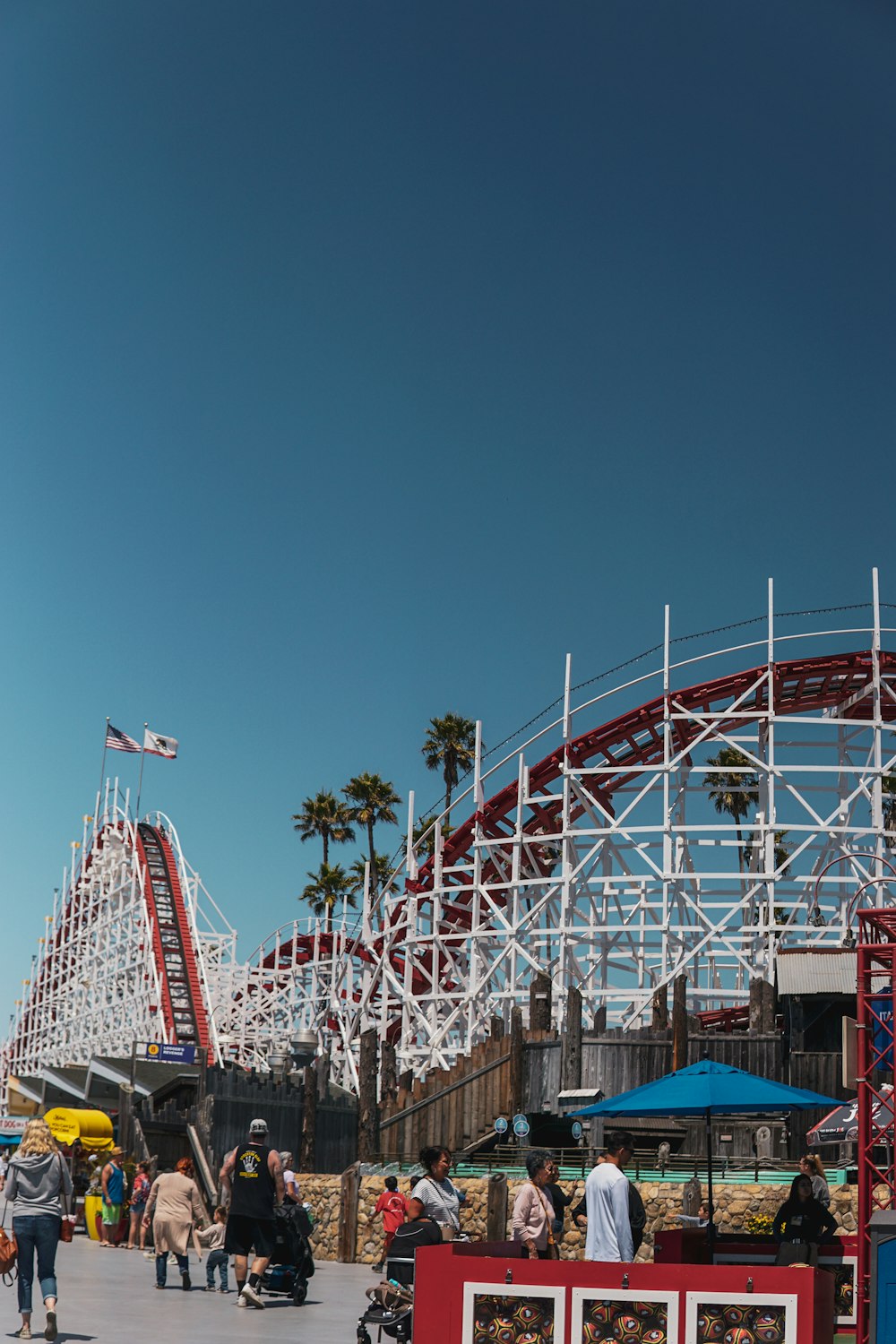 a group of people standing around a roller coaster