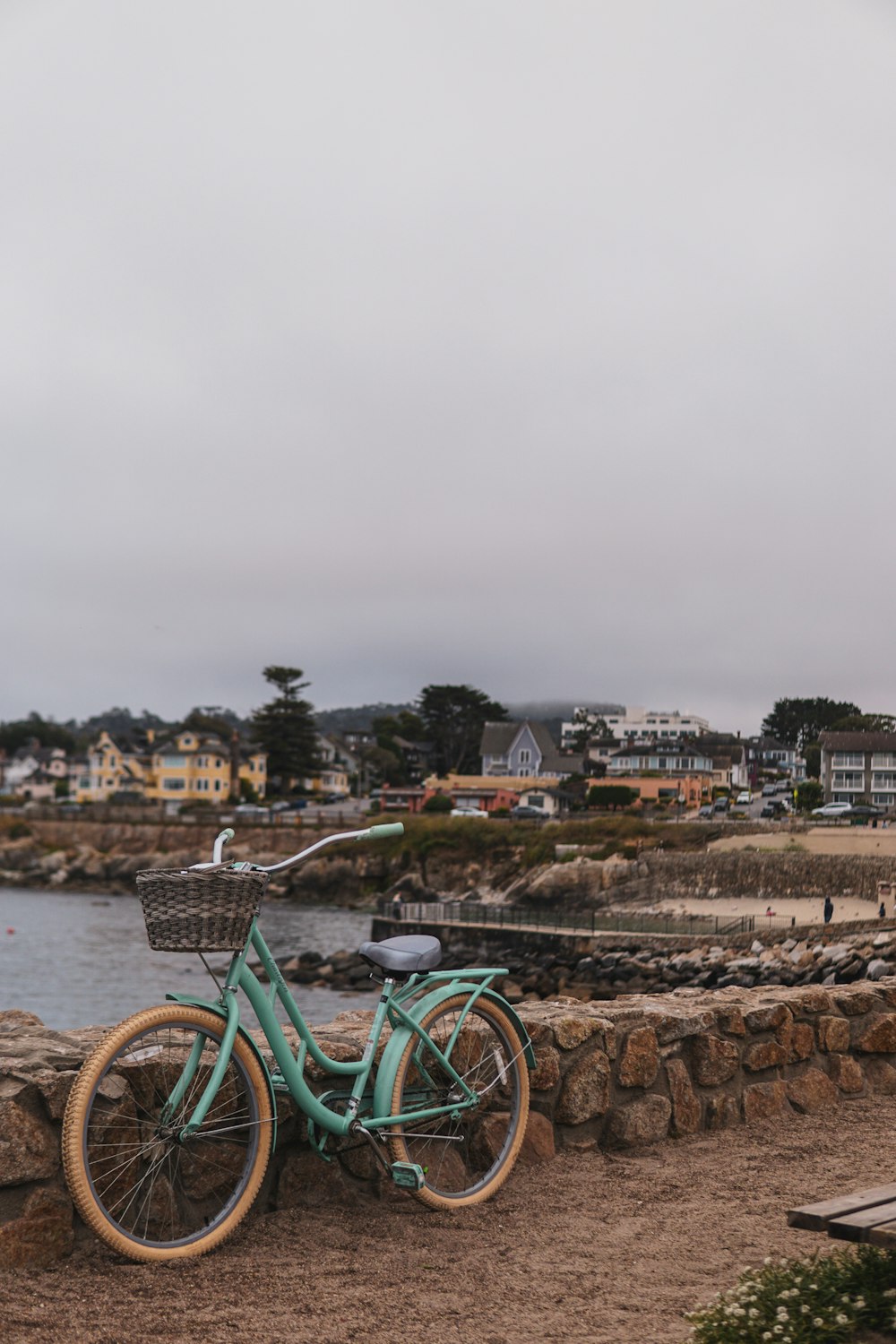 a blue bicycle parked next to a stone wall