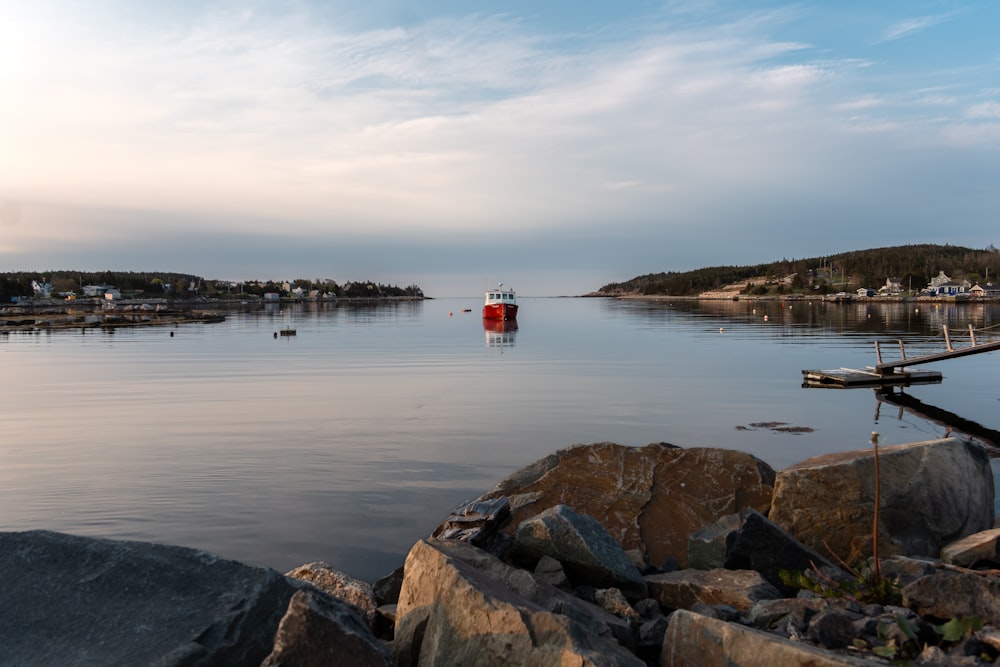 a boat is in the water near some rocks