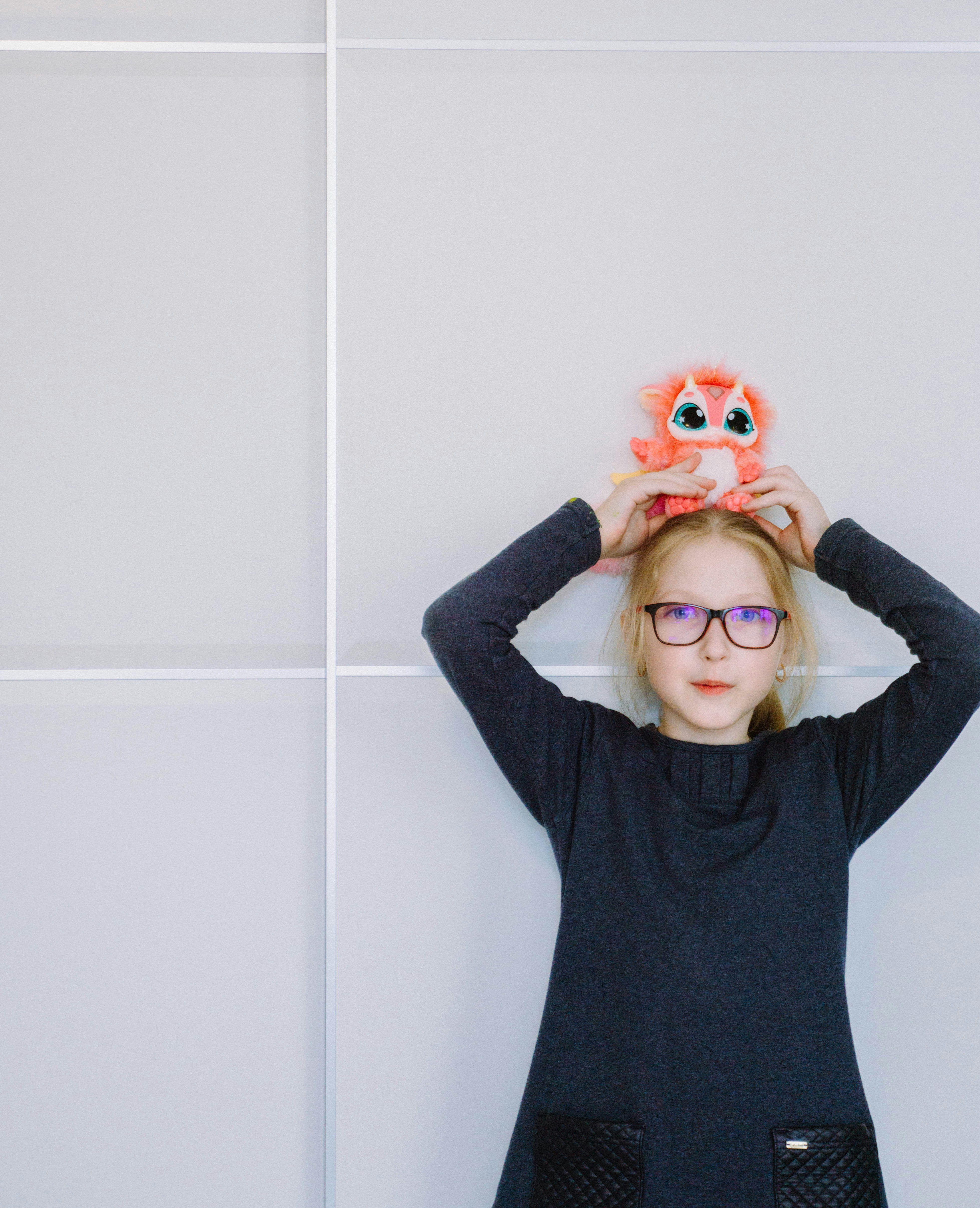 a little girl holding a pair of eyeballs over her head