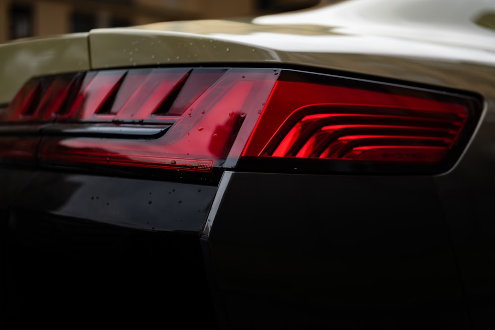 a close up of a car tail light with a building in the background