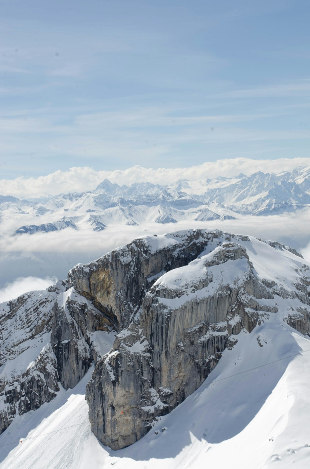 a mountain range covered in snow under a blue sky