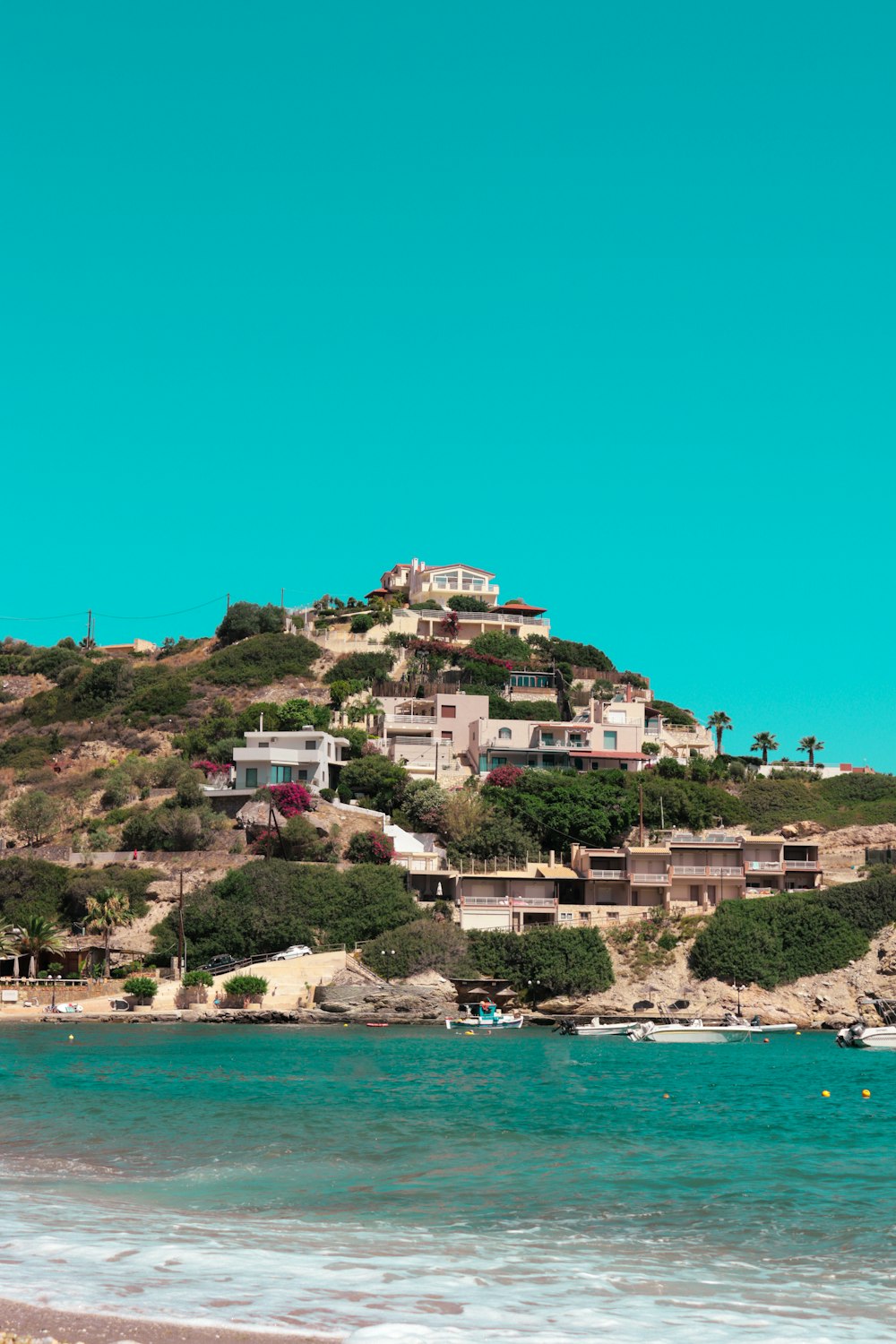 a hill with houses on top of it next to the ocean