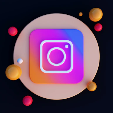 A digital artwork featuring a stylized Instagram logo centered on a circular, beige background. The logo is neon with a gradient of purple, pink, and blue. Surrounding the logo are various colored spheres in shades of red, orange, and yellow.