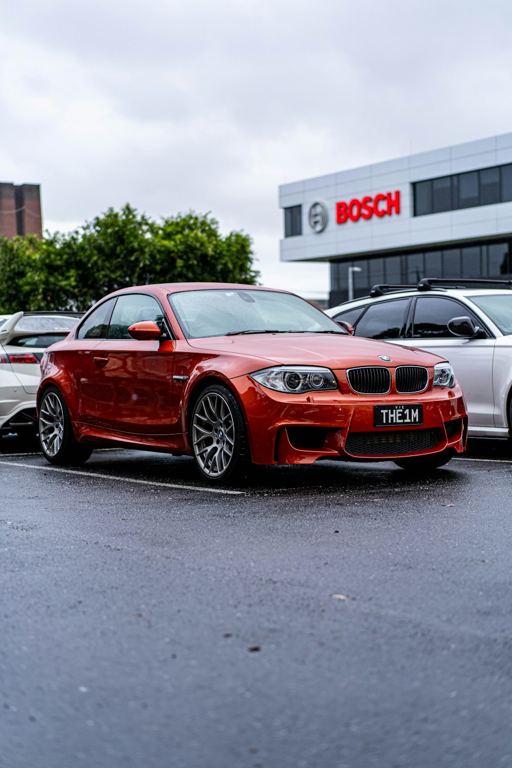 a red car parked in a parking lot next to other cars