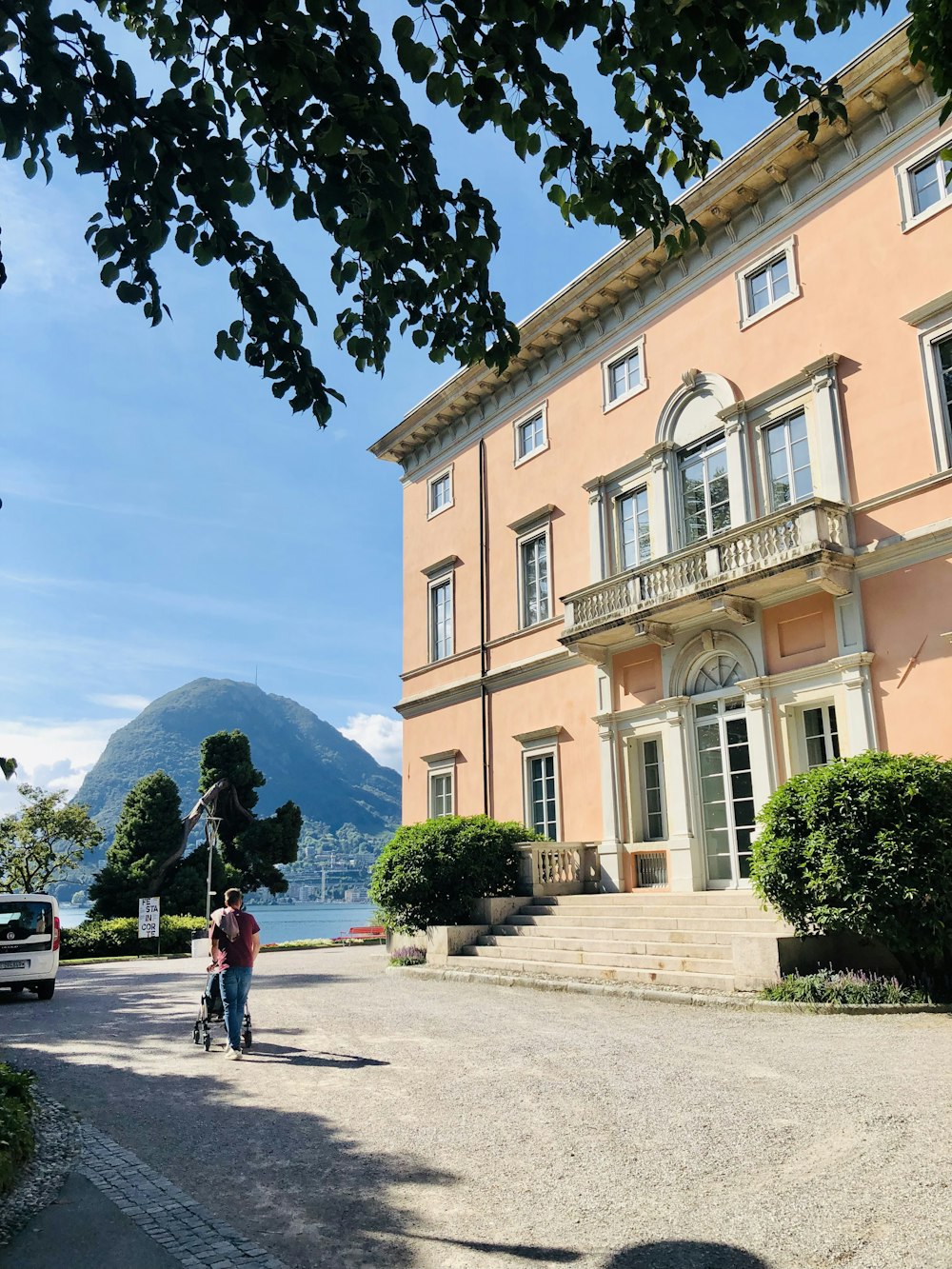 una persona che cammina lungo una strada di fronte a un grande edificio