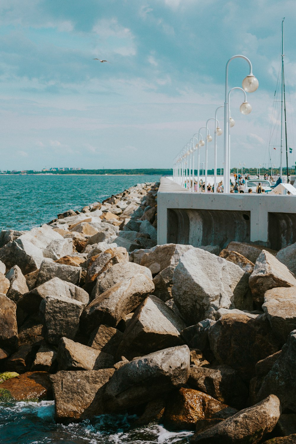 a group of people standing on a pier next to the ocean