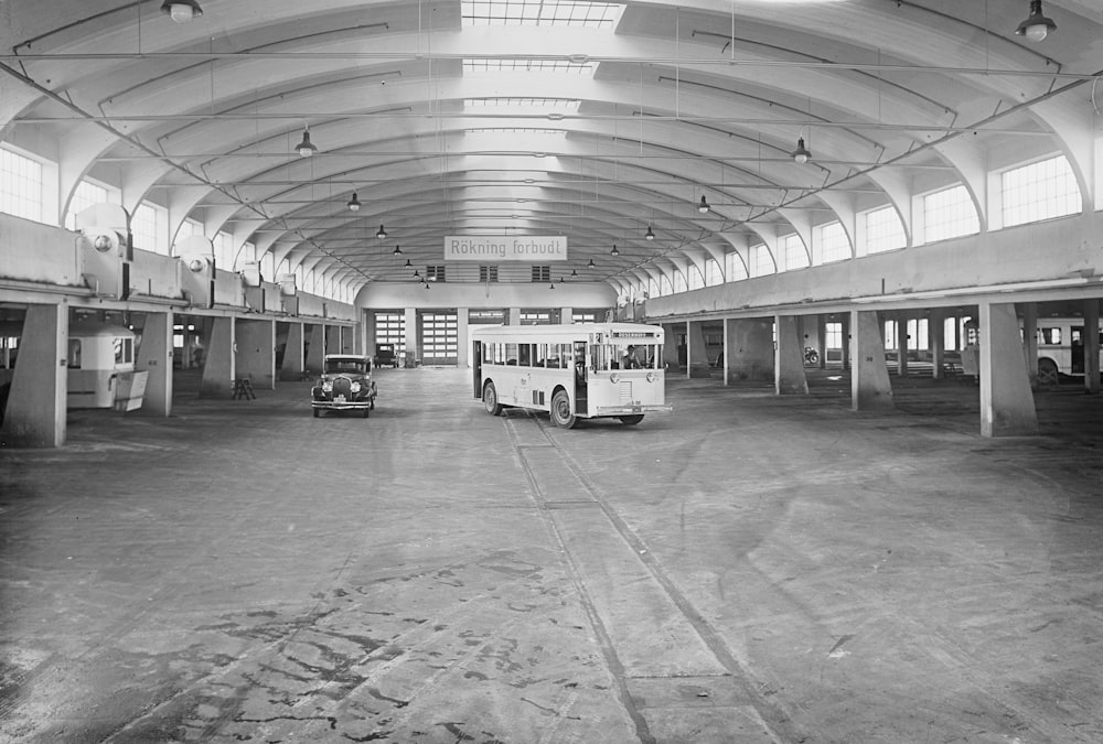 a black and white photo of a bus in a building