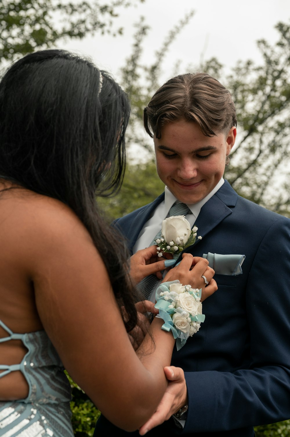 a man in a blue suit is looking at a woman in a blue dress