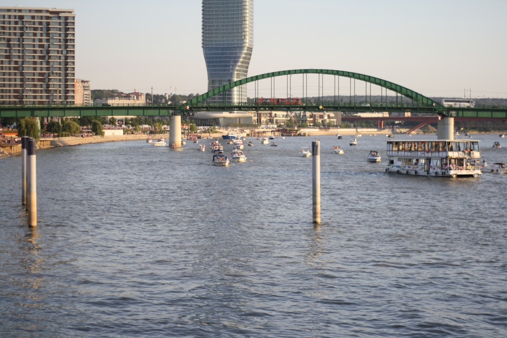 a river filled with lots of boats next to a tall building