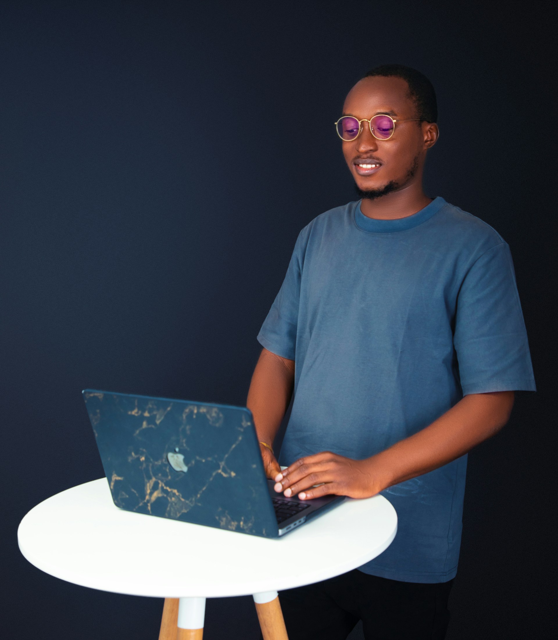 a man in a blue shirt is using a laptop