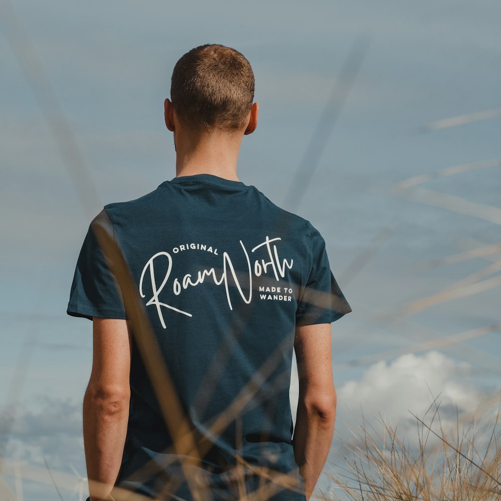 a man standing in a field with his back to the camera