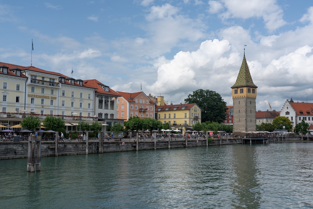 a body of water with buildings and a clock tower in the background