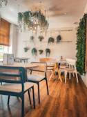 Cozy café interior featuring warm lighting and wooden furniture with tropical decor.