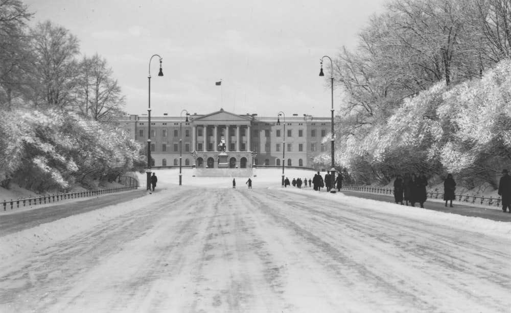 a black and white photo of people walking in front of a building