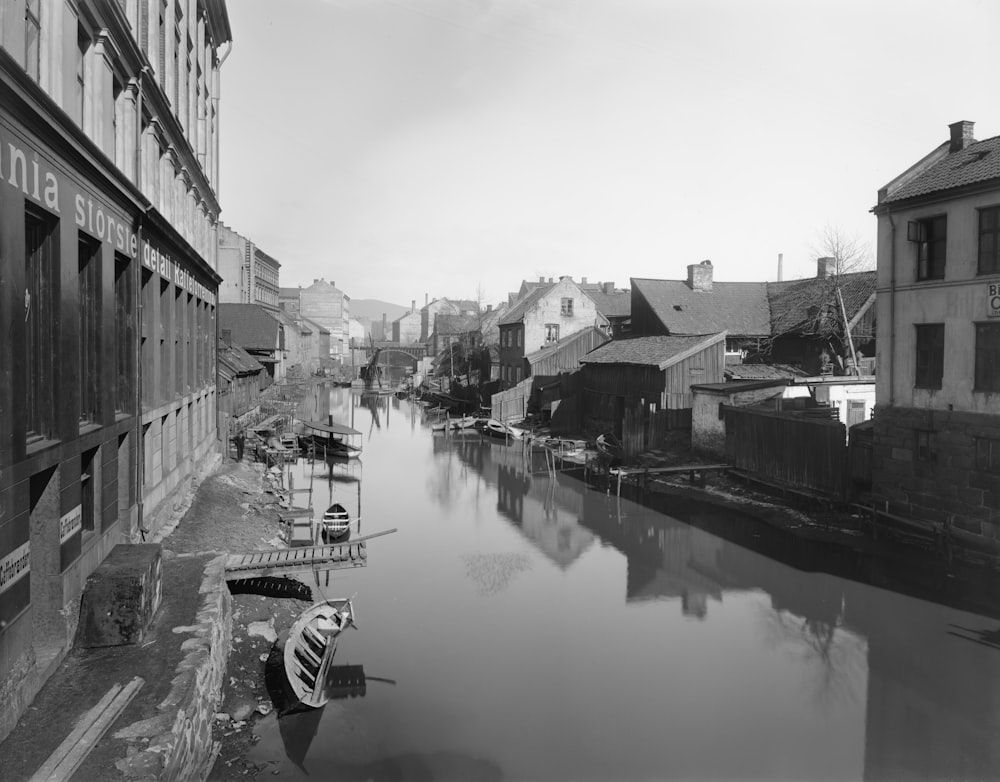 a black and white photo of a river running through a city