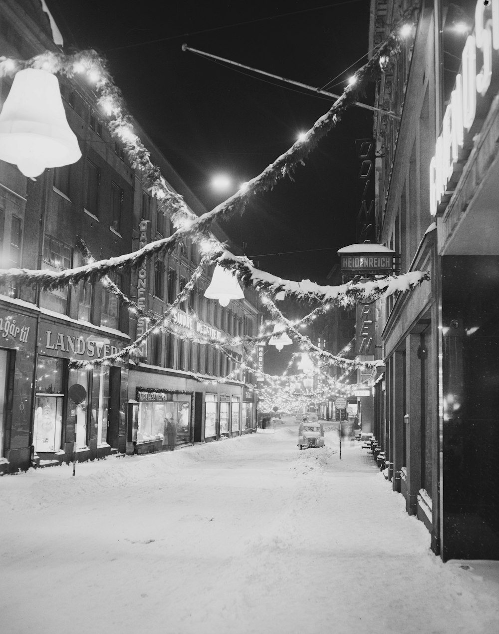 a black and white photo of a snowy street