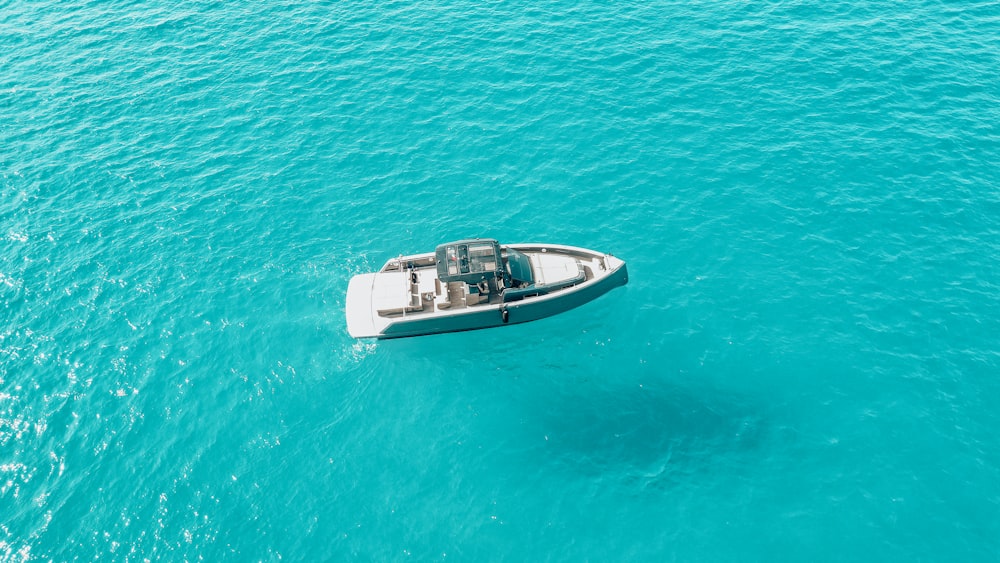 a small boat floating in the middle of the ocean