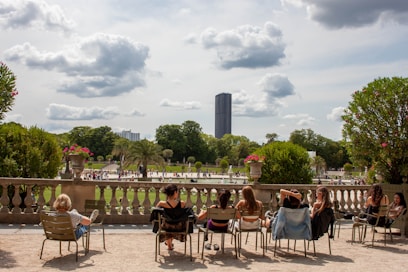 a group of people sitting on chairs in a park